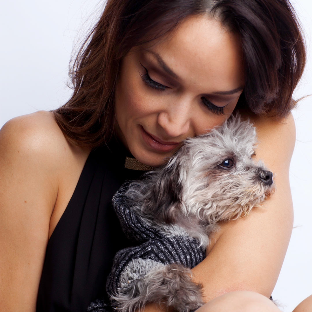 professional closeup portrait of Mayte holding a small fluffy dog